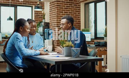 Angry manager throwing papers in meeting, feeling frustrated after failing to obtain business development results. Male worker feeling frustrated about employees work, examining statistics. Stock Photo