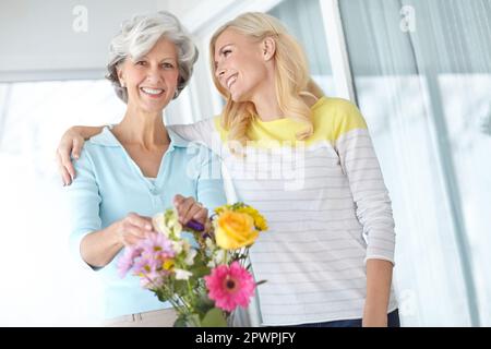 Learning from the master. Portrait of a senior woman enjoying some flower arranging with her daughter. Stock Photo