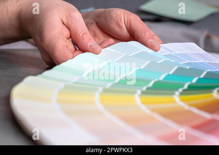 Hands designer or architect choosing swatch the colors painting of the walls in new apartment, design project. Renovation concept. Stock Photo