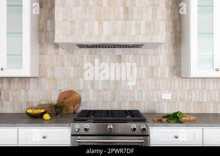 Stainless grey metal kitchen gas stove installed on a the kitchen with a  dark grey table top Stock Photo - Alamy