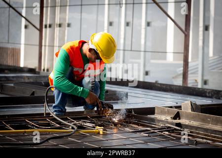 Young asian worker using machine welding iron with hands working in industrial factory, welder man or labor welding joint steel while having sparkle, Stock Photo