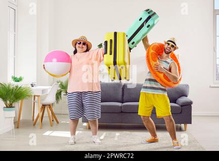 Happy couple of fat woman and smiling man in hats and sunglasses getting ready for holiday trip. Stock Photo