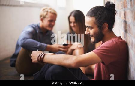Relaxing after a long lecture. three students relaxing in the hallway after class. Stock Photo