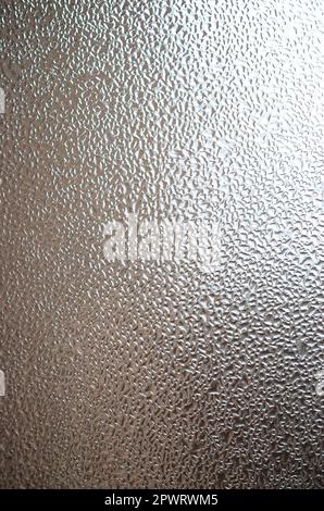 A photo of the glass surface of the window, covered with a multitude of droplets of various sizes. Background texture of a dense layer of condensate o Stock Photo