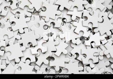 Close-up of a pile of uncompleted elements of a white puzzle. A huge number of rectangular pieces from one large white mosaic Stock Photo