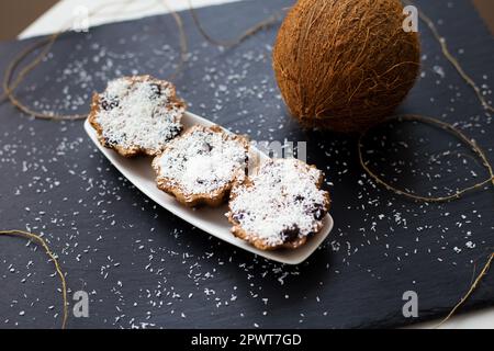 coconut muffins with chocolate on a black background and whole coconut Stock Photo
