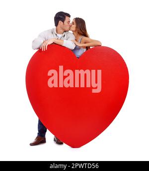 Lovely couple kissing behind heart shaped balloon on pink background ...
