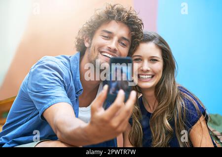 They make the cutest couple. a young couple taking a selfie outside. Stock Photo