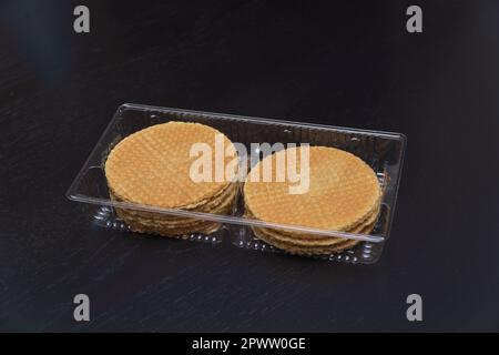 Delicious cookies in plastic packaging on a dark background Stock Photo