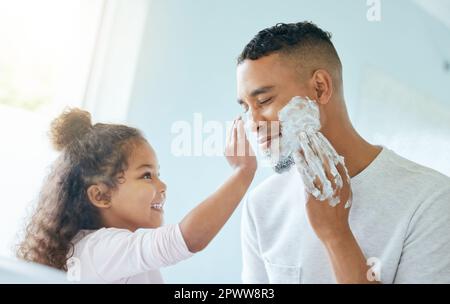 Let me help you with that. a little girl and her father playing around with shaving cream in a bathroom at home Stock Photo