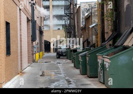 Alleyway with garbage bins and Hummer Auto in alley in Austin, Texas. Stock Photo
