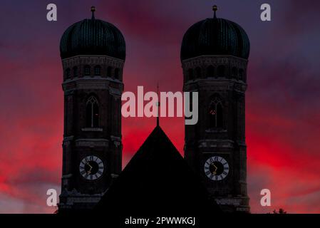 The silhouette of the two steeples of the Frauenkirche in Munich against a dramatic twilight sky Stock Photo
