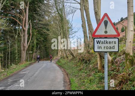 Cyclists on road with Walkers in Road sign on road beside Loweswater, Lake District, Cumbria Stock Photo