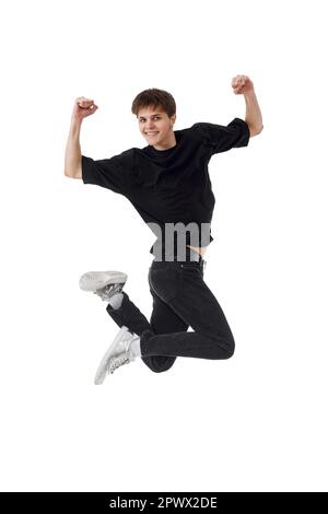 delighted young man in black t-shirt smiling jumping high isolated on white background Stock Photo