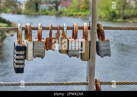 Padlocks on a footbridge over the River Cocker near the confluence with the River Derwent, Cockermouth, Lake District, Cumbria Stock Photo