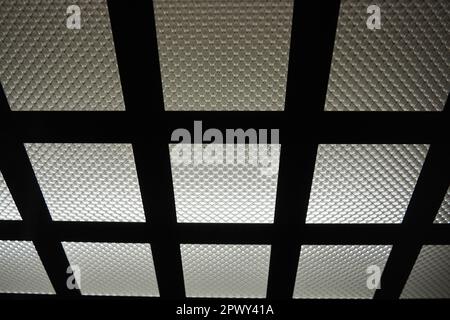 Electric LED light in the elevator. The ceiling of the elevator car. Checkered light source, horizontal and vertical metal lines and corrugated glass. Stock Photo