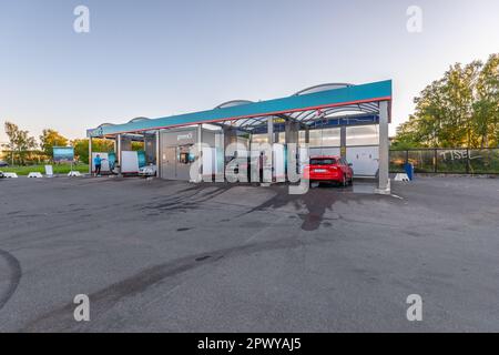 Falkenberg, Sweden - May 29 2021: Four cars being cleaned at a Glimra car wash. Stock Photo