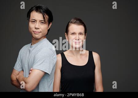 Studio portrait of happy man and woman in casual clothes looking at camera Stock Photo