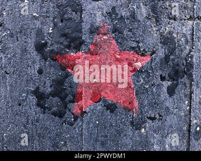 red five-pointed star on a black shabby background Stock Photo