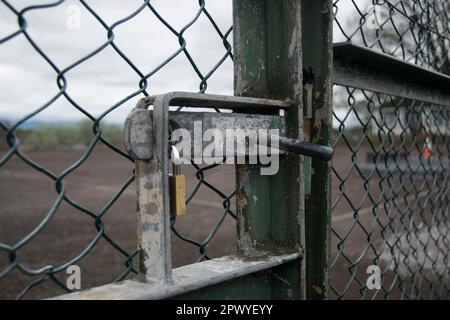 Padlocked gate of some tennis courts Stock Photo