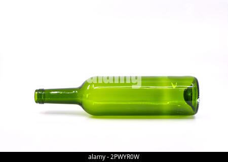 Empty green wine bottle lying on its side against a plain white background Stock Photo
