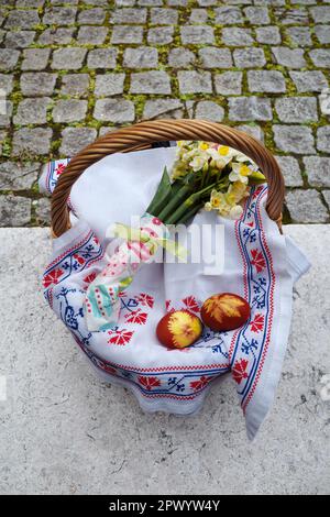 Easter basket decorated with flowers and containing Easter foods, ready to be brought to church for easter blessing Stock Photo