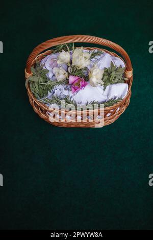 Easter basket on turquoise background, decorated with flowers and containing Easter foods, ready to be brought to church for easter blessing Stock Photo