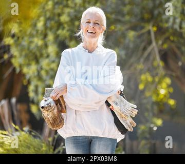 Beekeeper woman, portrait and smile with protective suit, happy and work outdoor in agriculture. Senior bee farmer, happy and beekeeping ppe at farm, Stock Photo