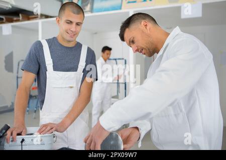 group of smiling builders with plastering tools indoors Stock Photo