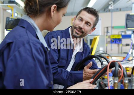 factory workers having conversation while at work Stock Photo