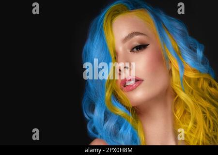 Portrait of beautiful woman with blue and yellow hair and classic make up and hairstyle. Stock Photo