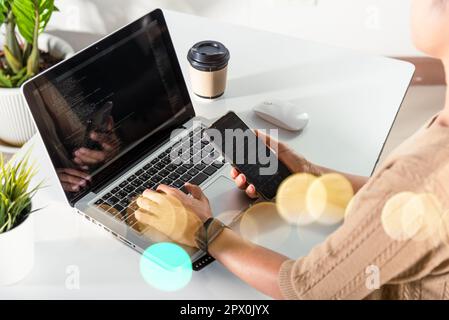 Software developer hands typing data coding programming javascript with laptop computer and mobile phone, Programmer woman looking smartphone program Stock Photo