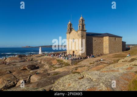 Muxia, A Coruna - Spain; August 30, 2022: Virxe de la Barca Sanctuary on Atlantic coast rocks in the foreground afternoon light Stock Photo