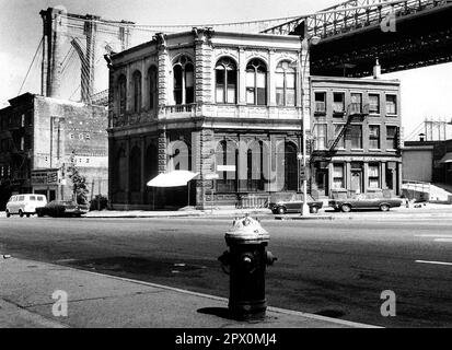 AJAXNETPHOTO. JULY, 1975. BROOKLYN, NEW YORK, USA. - OLD BANK - BROOKLYN BRIDGE TOWER EMERGING BEHIND NINETEENTH CENTURY COMMERCIAL BUILDINGS ON THE CORNER OF FRONT STREET AND CADMAN PLAZA WEST; THE OLD FULTON FERRY BANK AND TO ITS LEFT, THE OLDEST REMAINING 19TH CENTURY COMMERCIAL BUILDING BELOW THE DECK OF THE BROOKLYN BRIDGE SPANNING EAST RIVER BETWEEN PARK ROW MANHATTAN AND SANDS STREET, BROOKLYN, NEW YORK CiTY.  PHOTO:JONATHAN EASTLAND/AJAXREF:232404 120 Stock Photo