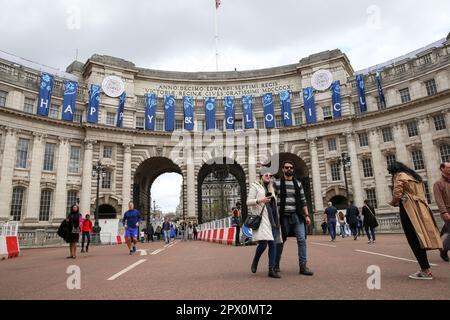 London, UK. 01st May, 2023. People walk past the words 'Happy & Glorious' displayed on Admiralty Arch in Westminster, central London as preparations for the Coronation of King Charles III continue. The Coronation of King Charles III and Queen Camilla will take place on May 6th with tens of thousands of people from around the world expected to line the route between Buckingham Palace and Westminster Abbey in central London. Credit: SOPA Images Limited/Alamy Live News Stock Photo