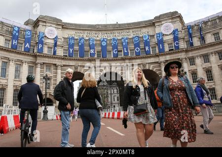 London, UK. 01st May, 2023. People walk past the words 'Happy & Glorious' displayed on Admiralty Arch in Westminster, central London as preparations for the Coronation of King Charles III continue. The Coronation of King Charles III and Queen Camilla will take place on May 6th with tens of thousands of people from around the world expected to line the route between Buckingham Palace and Westminster Abbey in central London. Credit: SOPA Images Limited/Alamy Live News Stock Photo