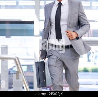 Late for a meeting...Closeup cropped image of a businessman with a briefcase going somewhere in a hurry. Stock Photo