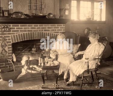 1930s TWO SENIOR GRANDMOTHERS SITTING TOGETHER BY FIREPLACE ONE ...
