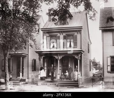 Three story wood frame house with partly visible basement, steps