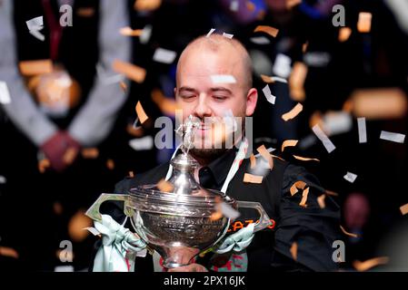 Luca Brecel celebrates with the trophy after beating Mark Selby to win the final on day seventeen of the Cazoo World Snooker Championship at the Crucible Theatre, Sheffield. Picture date: Monday May 1, 2023. Stock Photo