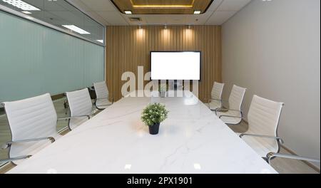 Conference room in a modern office building. Marble table, chair and large presentation monitor with blank screen prepare for a team meeting. Stock Photo