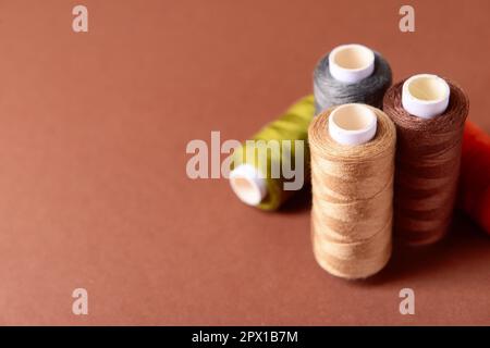 Multicolored sewing threads on color background Stock Photo