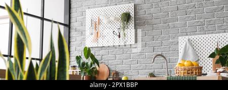 Kitchen interior with modern pegboards hanging on grey brick wall Stock Photo