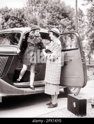 1930s MOM HELPING YOUNG DAUGHTER OUT OF CAR STEPPING ON THE RUNNING BOARD BOTH WEARING SPRING COATS SUITCASE ON SIDEWALK - m4599 v2 HAR001 HARS OLD TIME NOSTALGIA OLD FASHION AUTO 1 JUVENILE STYLE MOTOR VEHICLE YOUNG ADULT VACATION FAMILIES LIFESTYLE SATISFACTION FEMALES COATS STEPPING HOME LIFE COPY SPACE FRIENDSHIP FULL-LENGTH LADIES DAUGHTERS PERSONS AUTOMOBILE CONFIDENCE TRANSPORTATION B&W TIME OFF HAPPINESS ADVENTURE TRIP AUTOS GETAWAY LOW ANGLE HOLIDAYS MOTHER AND DAUGHTER CONNECTION AUTOMOBILES STYLISH SUPPORT VEHICLES GROWTH JUVENILES MOMS TOGETHERNESS VACATIONS YOUNG ADULT WOMAN Stock Photo