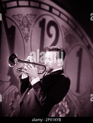 1960s MAN PLAYING A TRUMPET IN FRONT OF A CLOCK FACE ABOUT TO STRIKE MIDNIGHT - m8013 HAR001 HARS RISK ENTERTAINMENT CONFIDENCE B&W PERFORMING ARTS SUIT AND TIE HAPPINESS EXCITEMENT STRIKE NEW YEAR'S FACIAL HAIR OCCUPATIONS MUSICAL INSTRUMENT CONCEPTUAL IMAGINATION MIDNIGHT STYLISH BEARDS GROWTH YOUNG ADULT MAN BLACK AND WHITE CAUCASIAN ETHNICITY HAR001 JANUARY 1 NEW YEAR NEW YEARS OLD FASHIONED Stock Photo