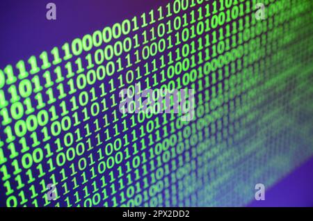 Macro shot of binary code on the monitor of an office computer. The concept of the programmer's work. The flow of digital information strings Stock Photo