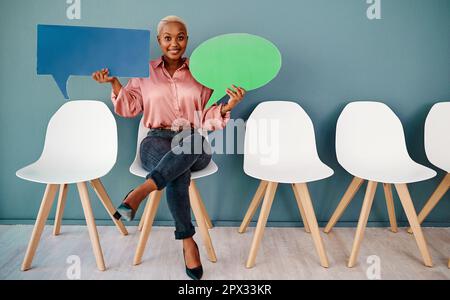 You can also join in the conversation. Studio portrait of an attractive young businesswoman holding up speech bubbles while sitting in line against a Stock Photo