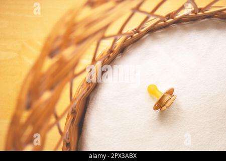 Baby pastel pacifier on a white background in baby basket. Stock Photo