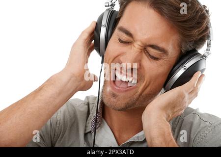 Singing along with his favourite song. A handsome young man listening to music with his eyes closed. Stock Photo
