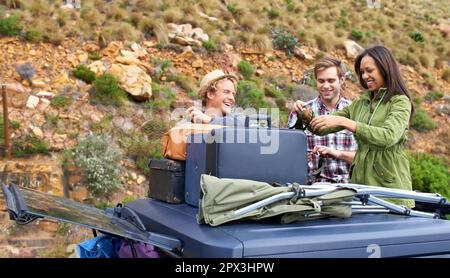 Ready to set up camp. A group of young people unloading their luggage on a camping trip. Stock Photo